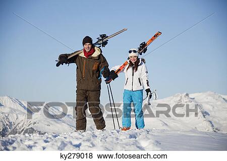 Stock Photo - Father and daughter carrying skis. Fotosearch