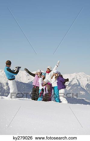 Man taking picture of family in snow View Large Photo Image Stock Photograph - Man taking picture of family in snow. Fotosearch