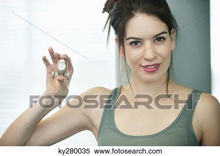 Portrait of a woman showing a clock and smiling View Large Photo Image Stock Photography - Portrait of a woman showing a clock and smiling. Fotosearch