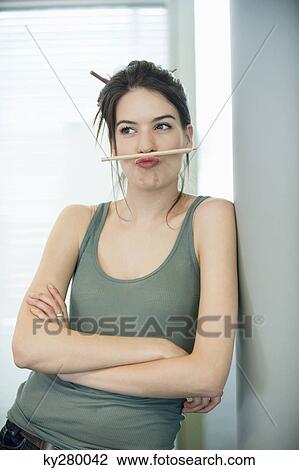 Woman balancing a pencil on lip View Large Photo Image Stock Image - Woman balancing a pencil on lip. Fotosearch