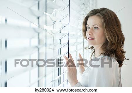 Woman looking out of a window View Large Photo Image Picture - Woman looking out of a window. Fotosearch