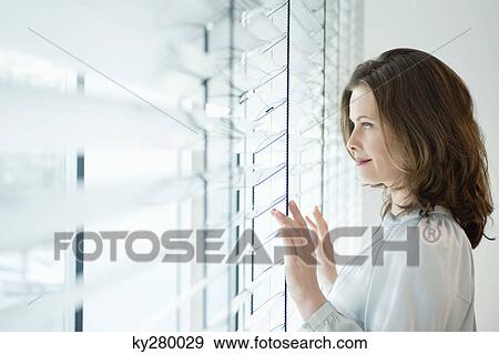 Woman looking out of a window View Large Photo Image Stock Photo - Woman looking out of a window. Fotosearch