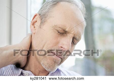 Close-up of a man rubbing his neck View Large Photo Image Stock Image - Close-up of a man rubbing his neck. Fotosearch