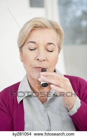 Close-up of a woman smelling aromatherapy oil View Large Photo Image Picture - Close-up of a woman smelling aromatherapy oil. Fotosearch