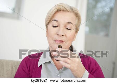 Close-up of a woman smelling aromatherapy oil View Large Photo Image Stock Image - Close-up of a woman smelling aromatherapy oil. Fotosearch