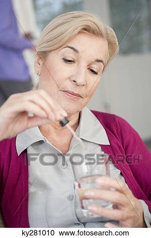 Stock Image - Close-up of a woman taking medicine. Fotosearch