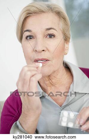 Stock Image - Close-up of a woman taking medicine. Fotosearch
