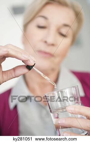 Stock Image - Close-up of a woman taking medicine. Fotosearch