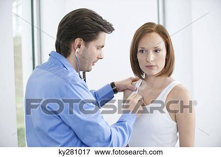 Doctor examining a patient with a stethoscope View Large Photo Image Stock Photo - Doctor examining a patient with a stethoscope. Fotosearch