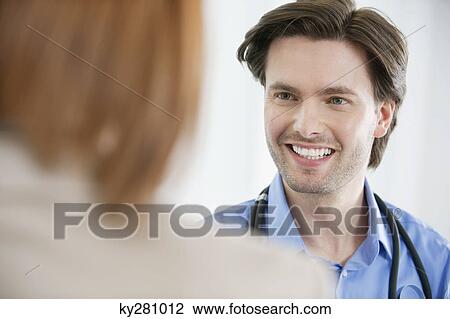 Doctor looking at a woman View Large Photo Image Stock Image - Doctor looking at a woman. Fotosearch