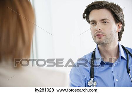 Doctor looking at a woman View Large Photo Image Stock Photo - Doctor looking at a woman. Fotosearch