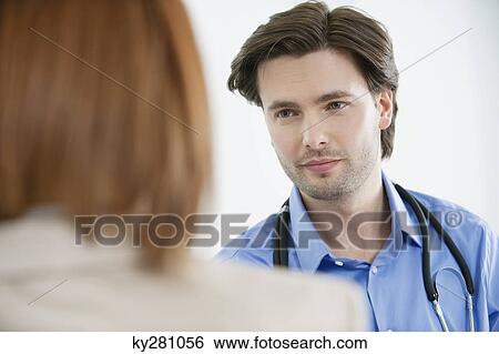 Stock Photograph - Doctor looking at a woman. Fotosearch