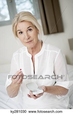 Portrait of a woman taking a capsule View Large Photo Image Stock Image - Portrait of a woman taking a capsule. Fotosearch
