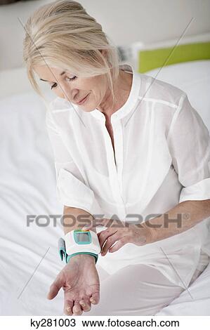 Woman checking her blood pressure View Large Photo Image Stock Image - Woman checking her blood pressure. Fotosearch