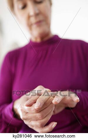Stock Photograph - Woman suffering from finger pain. Fotosearch