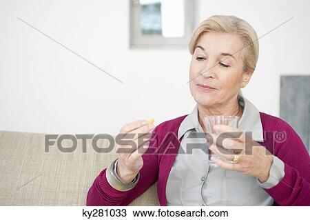 Woman taking a capsule View Large Photo Image Stock Image - Woman taking a capsule. Fotosearch