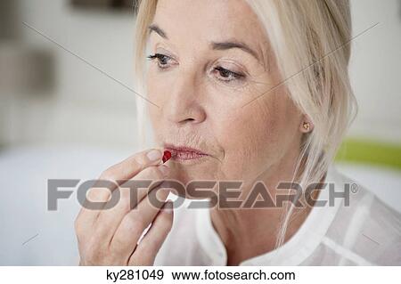 Stock Photo - Woman taking a capsule. Fotosearch
