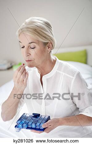 Woman taking a capsule View Large Photo Image Stock Photograph - Woman taking a capsule. Fotosearch