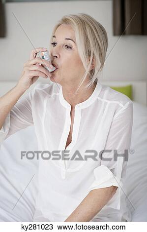 Woman using an asthma inhaler View Large Photo Image Stock Image - Woman using an asthma inhaler. Fotosearch
