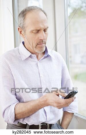 Close-up of a man text messaging on a mobile phone View Large Photo Image Stock Photography - Close-up of a man text messaging on a mobile phone. Fotosearch