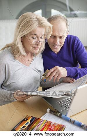 Couple shopping online with a laptop View Large Photo Image Picture - Couple shopping online with a laptop. Fotosearch