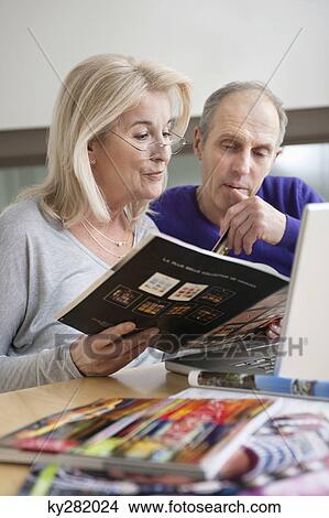 Couple shopping online with a laptop View Large Photo Image Picture - Couple shopping online with a laptop. Fotosearch