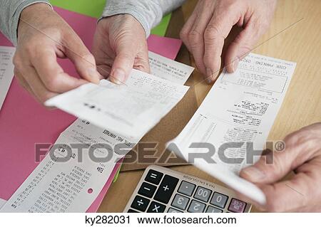 Stock Image - Couple sorting out bills. Fotosearch