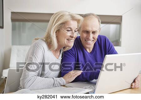 Couple using a laptop View Large Photo Image Stock Image - Couple using a laptop. Fotosearch
