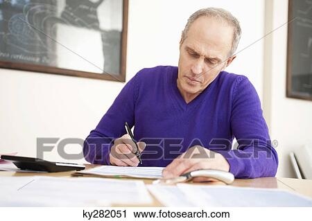 Stock Image - Man filling his tax form. Fotosearch