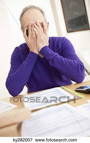 Man looking worried while filling his tax form View Large Photo Image Stock Photo - Man looking worried while filling his tax form. Fotosearch