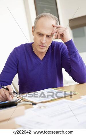 Man using calculator and filling his tax form View Large Photo Image Stock Image - Man using calculator and filling his tax form. Fotosearch