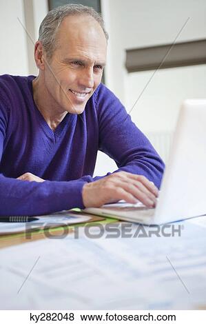 Man working on a laptop View Large Photo Image Stock Photo - Man working on a laptop. Fotosearch