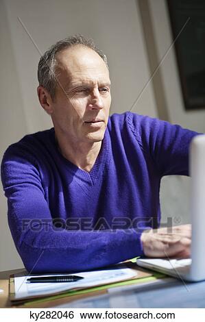 Man working on a laptop View Large Photo Image Stock Photograph - Man working on a laptop. Fotosearch