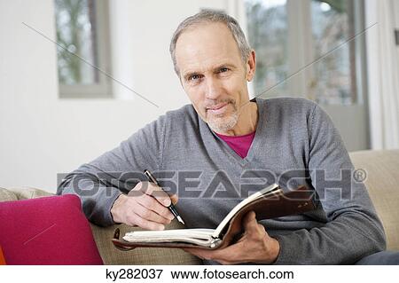 Man writing in a personal organizer View Large Photo Image Stock Photo - Man writing in a personal organizer. Fotosearch