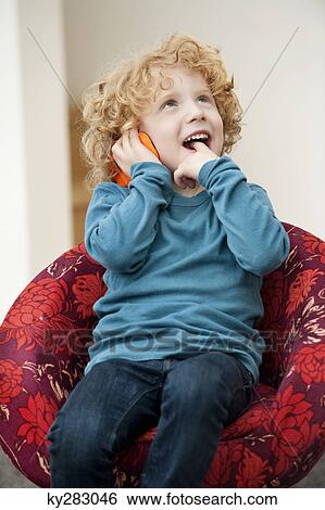 Boy talking on a mobile phone View Large Photo Image Stock Photograph - Boy talking on a mobile phone. Fotosearch