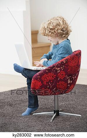 Boy using a laptop View Large Photo Image Stock Image - Boy using a laptop. Fotosearch