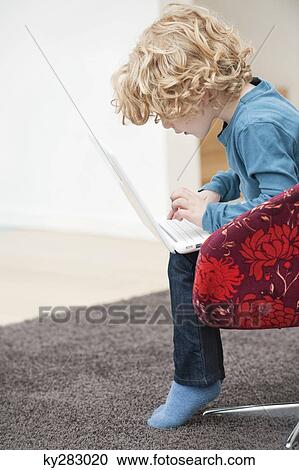 Stock Image - Boy using a laptop. Fotosearch