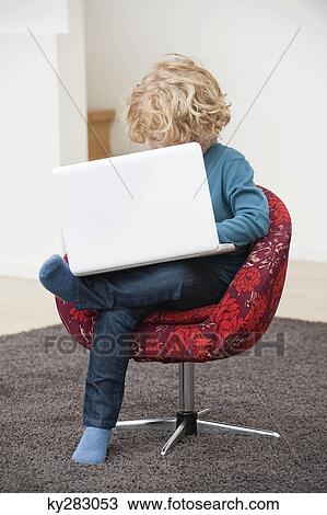 Boy using a laptop View Large Photo Image Stock Image - Boy using a laptop. Fotosearch