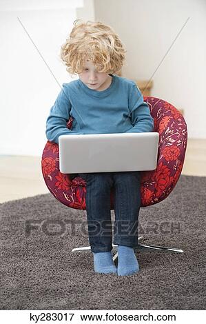 Stock Photo - Boy using a laptop. Fotosearch