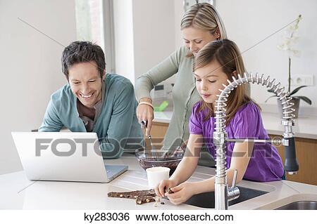Family cooking with the recipe on a laptop View Large Photo Image Stock Photograph - Family cooking with the recipe on a laptop. Fotosearch