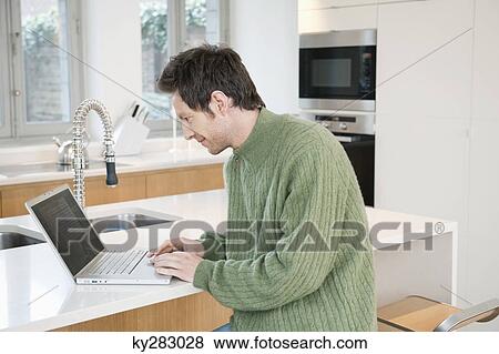 Man working on a laptop View Large Photo Image Stock Photo - Man working on a laptop. Fotosearch