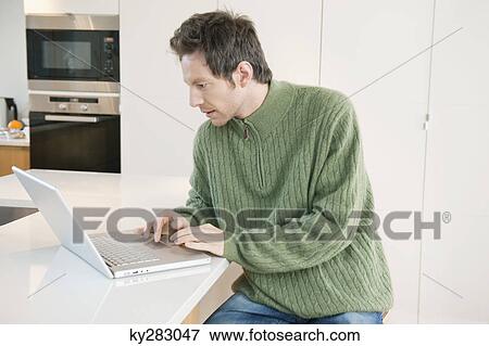Man working on a laptop View Large Photo Image Stock Photo - Man working on a laptop. Fotosearch
