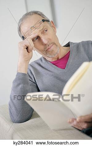 Man holding a book and thinking View Large Photo Image Stock Image - Man holding a book and thinking. Fotosearch
