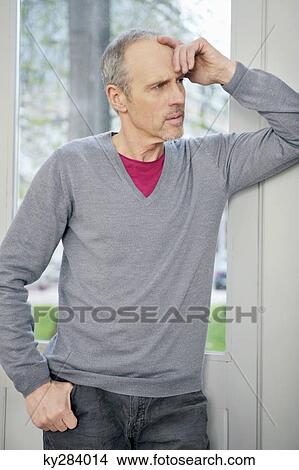 Man standing in front of a window and thinking View Large Photo Image Picture - Man standing in front of a window and thinking. Fotosearch