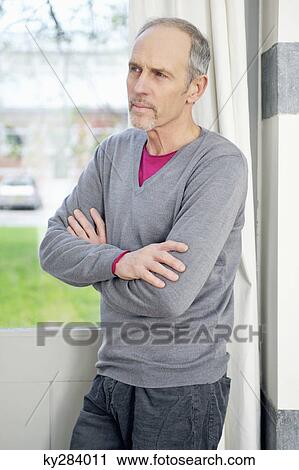 Man standing in front of a window and thinking View Large Photo Image Stock Image - Man standing in front of a window and thinking. Fotosearch
