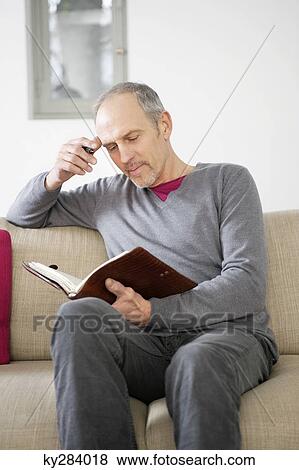Man writing in a personal organizer View Large Photo Image Stock Photo - Man writing in a personal organizer. Fotosearch