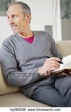 Man writing in a personal organizer View Large Photo Image Stock Photo - Man writing in a personal organizer. Fotosearch