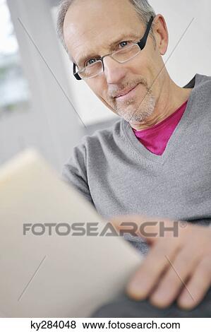 Portrait of a man holding a book View Large Photo Image Stock Photo - Portrait of a man holding a book. Fotosearch