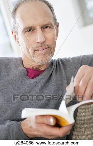 Portrait of a man holding a book View Large Photo Image Stock Photograph - Portrait of a man holding a book. Fotosearch