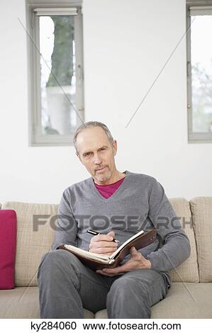 Portrait of a man writing in a personal organizer View Large Photo Image Stock Image - Portrait of a man writing in a personal organizer. Fotosearch